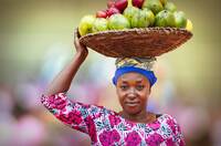 African woman carrying basket full of fruits