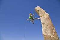 A rock climber rappelling from a rock spire in Joshua Tree National Park