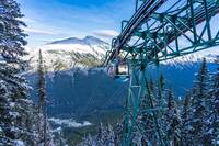 Gondola at Banff National Park with snow-topped mountains in background